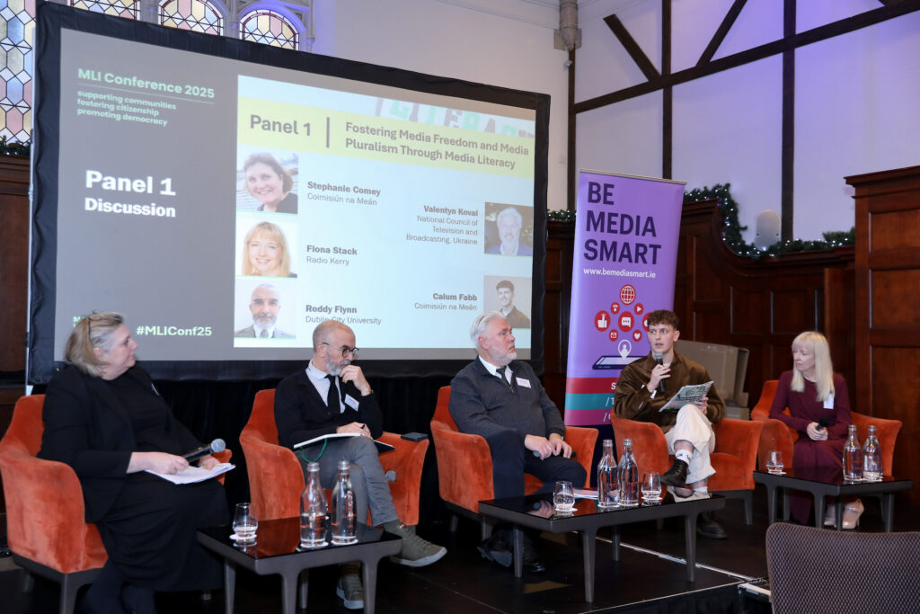 Moderator and four panellists seated.