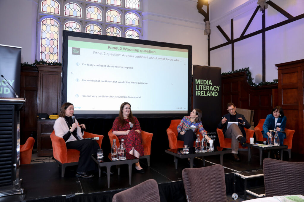 Moderator and four panellists seated.