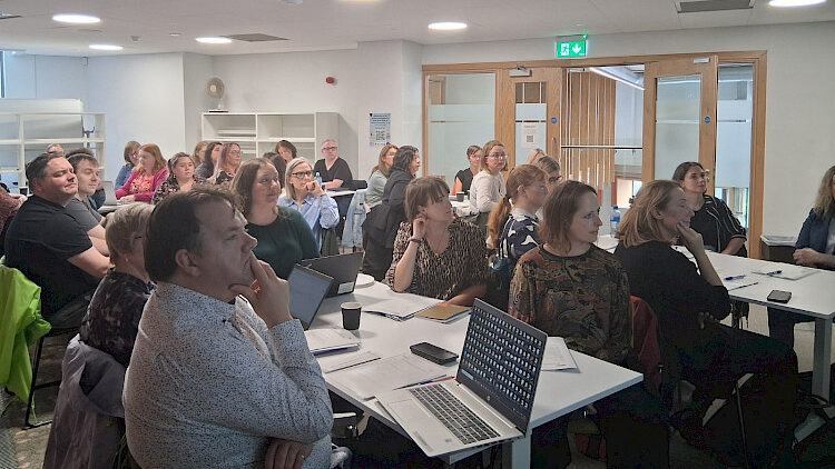 large group of people listening to presentation